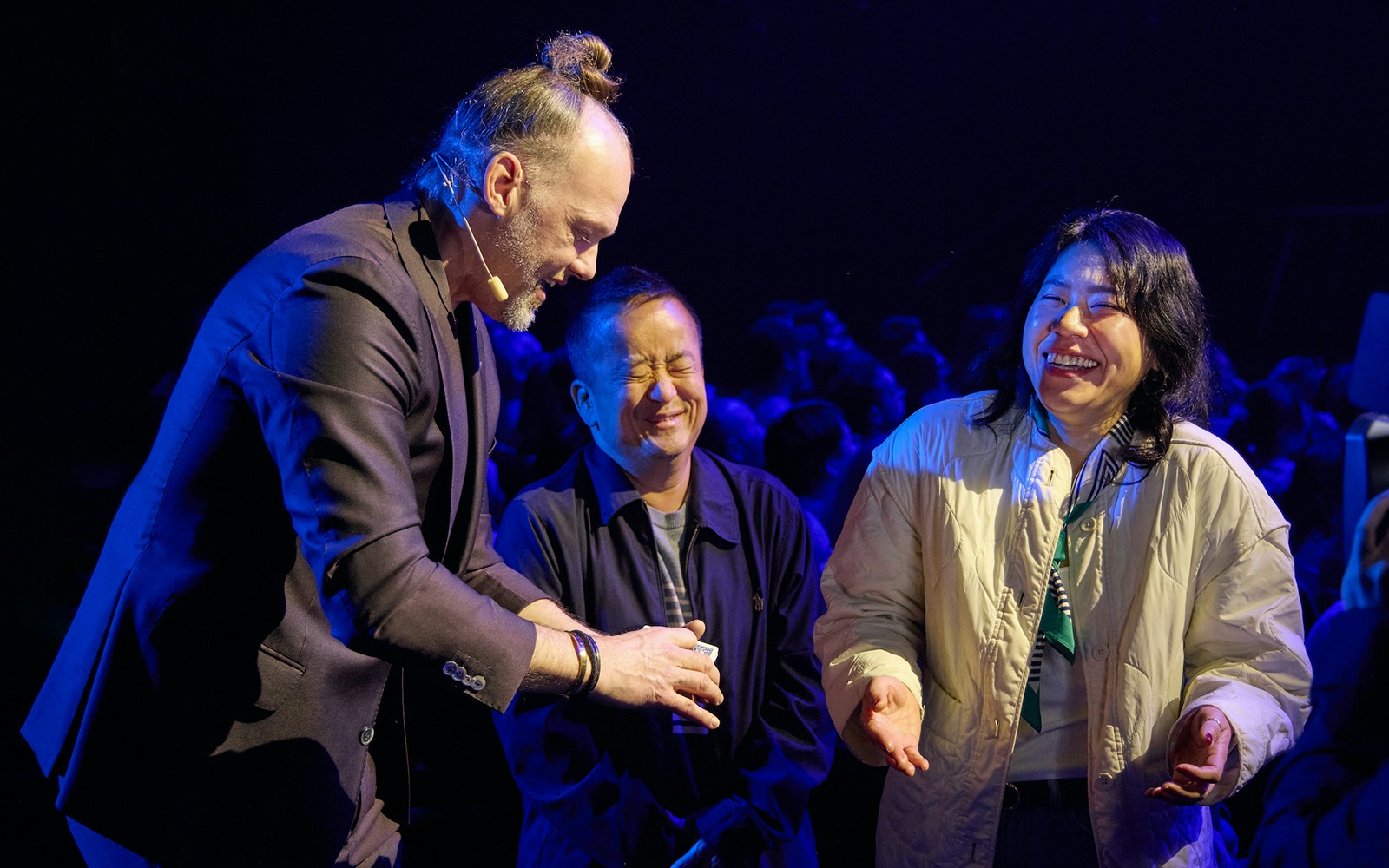 Magician performing card trick for audience during Stalker show.