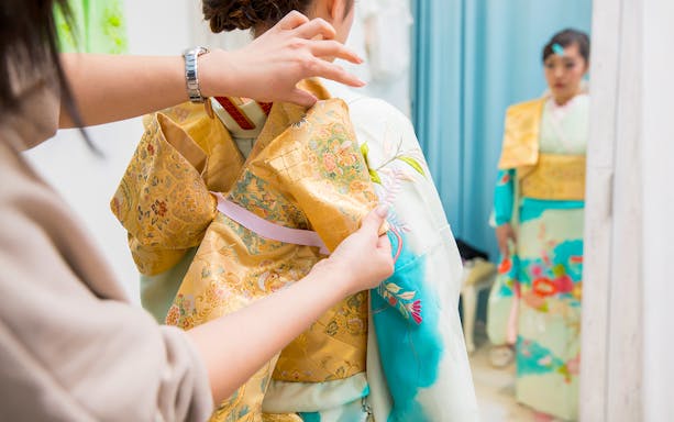 Adjusting a kimono in a Kyoto rental shop.