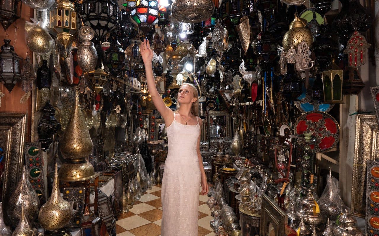Woman exploring a lantern shop in Agadir, surrounded by traditional Moroccan lamps and decor.