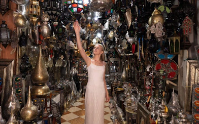 Woman exploring a lantern shop in Agadir, surrounded by traditional Moroccan lamps and decor.