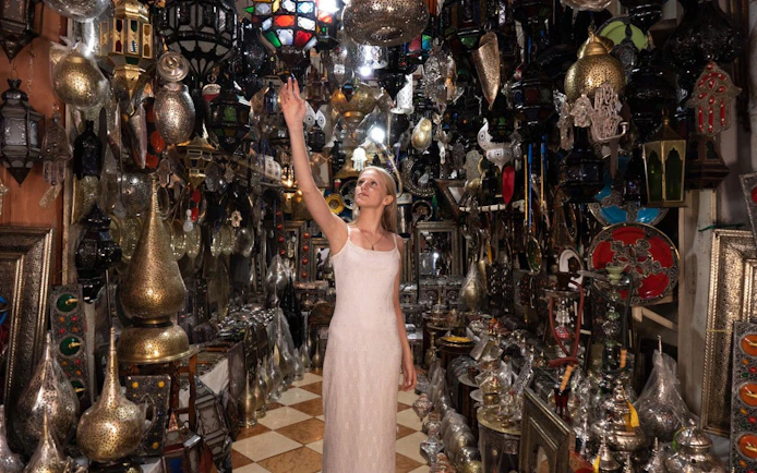 Woman exploring a lantern shop in Agadir, surrounded by traditional Moroccan lamps and decor.