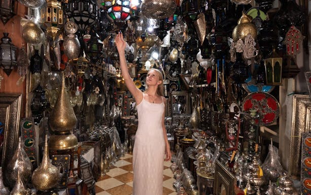 Woman exploring a lantern shop in Agadir, surrounded by traditional Moroccan lamps and decor.