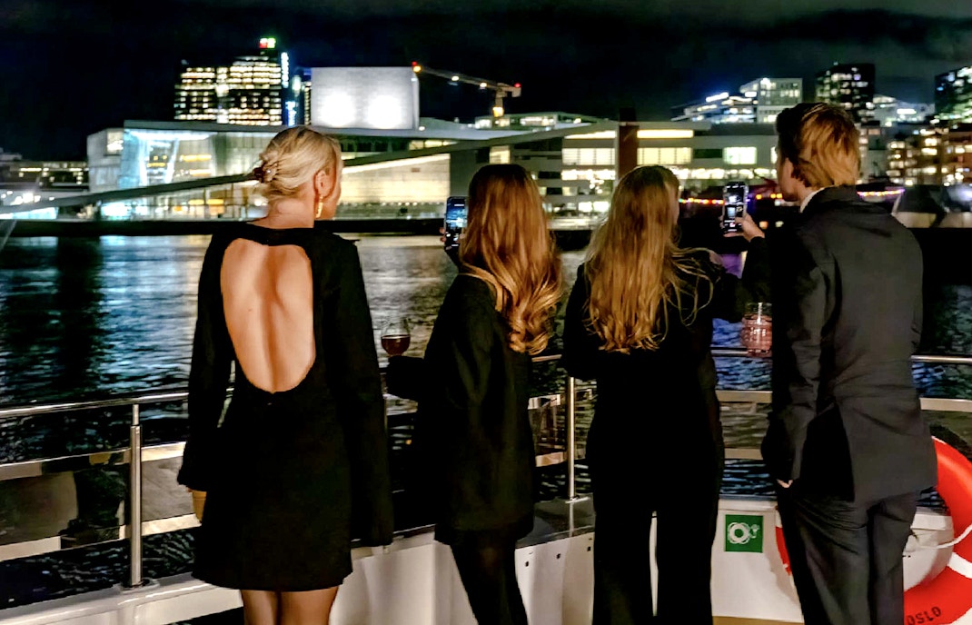 Oslo fjord dinner cruise boat with passengers enjoying scenic views.