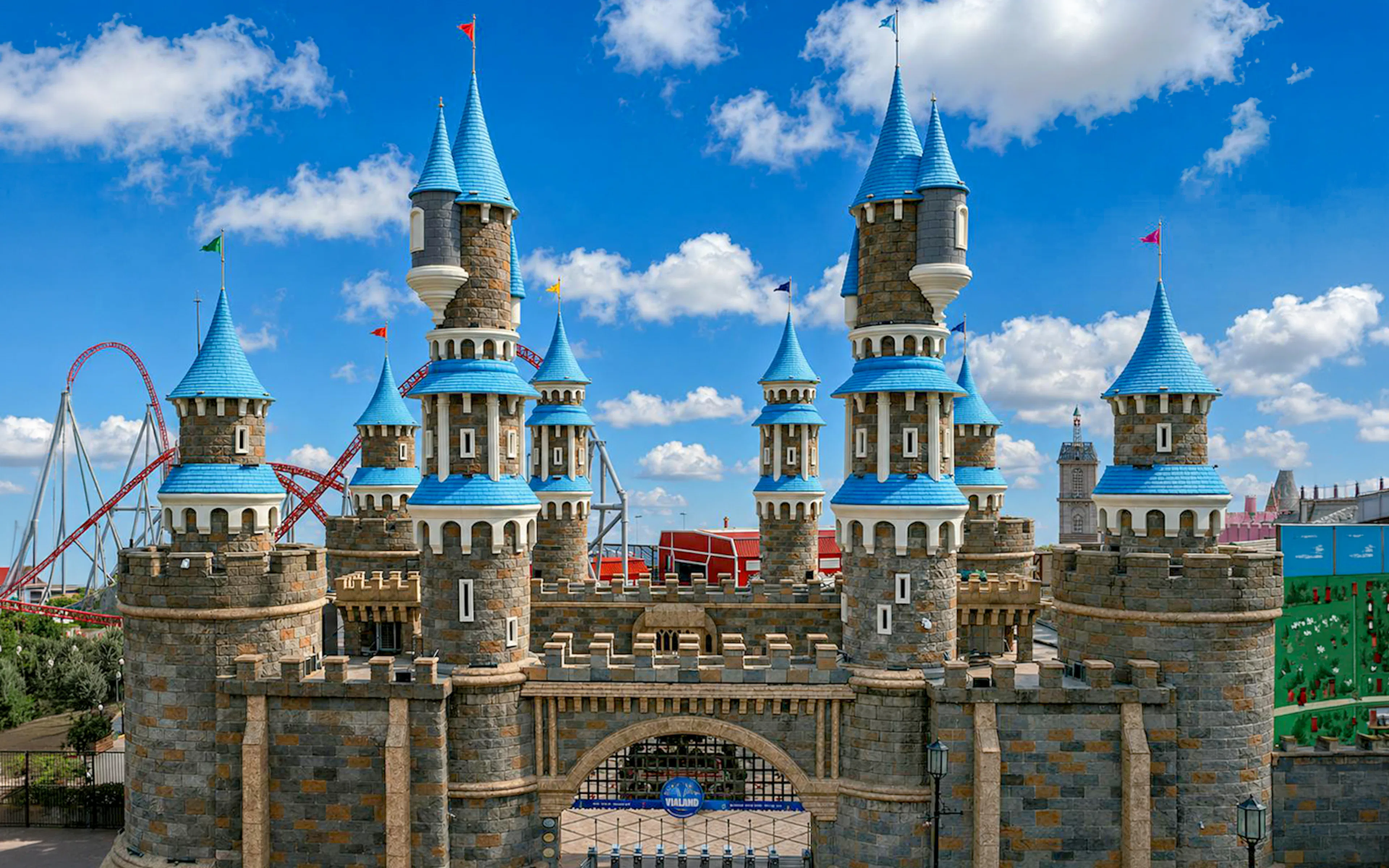 Entrance of Vialand Theme Park in Istanbul with castle towers and roller coaster in background.
