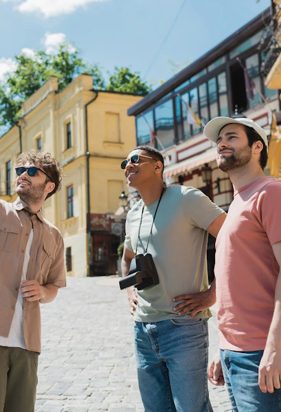 Tourists exploring a historic street with yellow buildings in a European city.