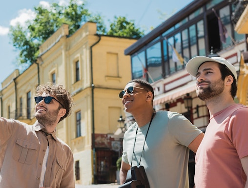 Tourists exploring a historic street with yellow buildings in a European city.