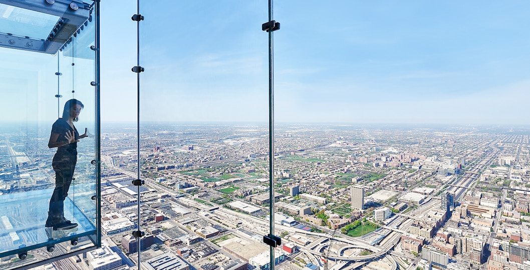 View from Skydeck at Willis Tower, Chicago, overlooking city skyline and Lake Michigan.