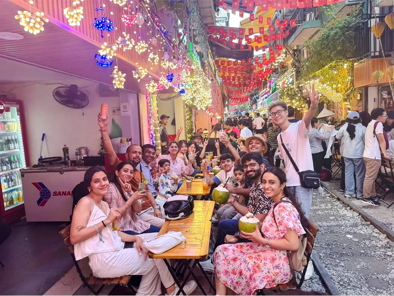 Group enjoying street food at a vibrant night market in Hanoi during a Jeep culture tour.