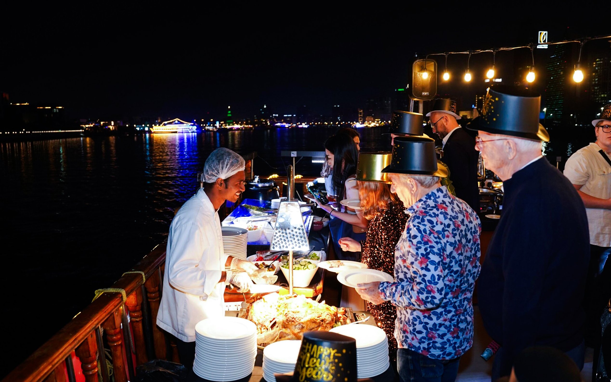Guests enjoying a buffet on a New Year's Eve Creek Dhow Dinner Cruise.
