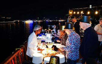 Guests enjoying a buffet on a New Year's Eve Creek Dhow Dinner Cruise.
