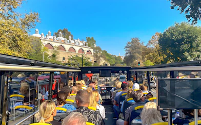 Open-top bus tour in Istanbul passing by historic architecture.
