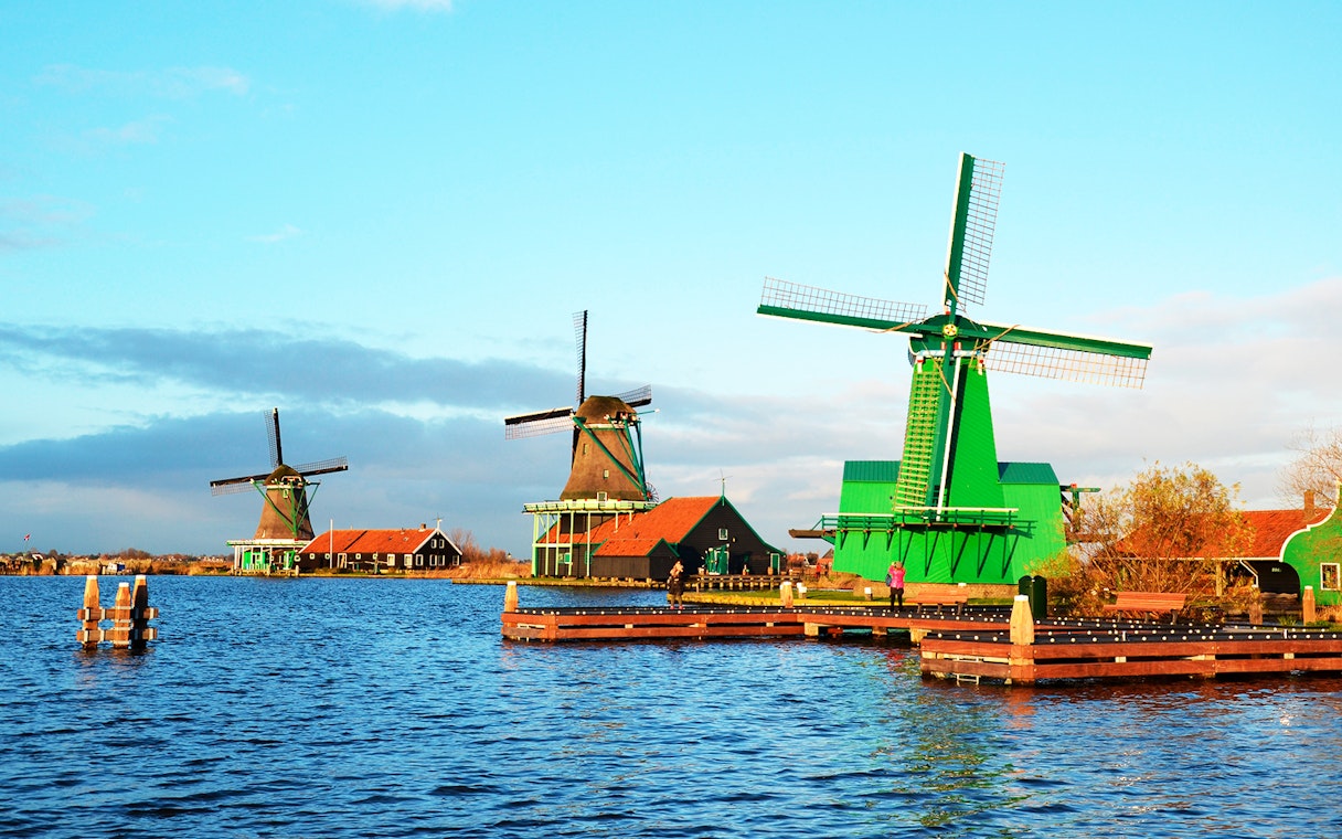 Windmills at Zaanse Schans by the water in the Netherlands.