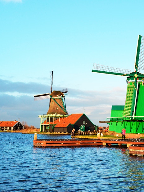Windmills at Zaanse Schans by the water in the Netherlands.