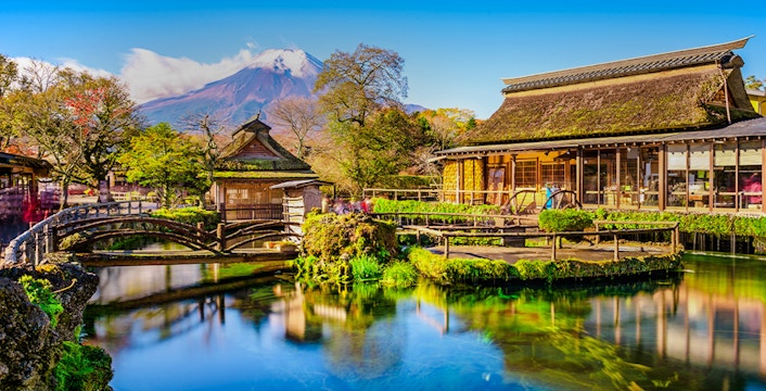 Oshino Hakkai village pond with traditional buildings and Mount Fuji in the background, Japan.