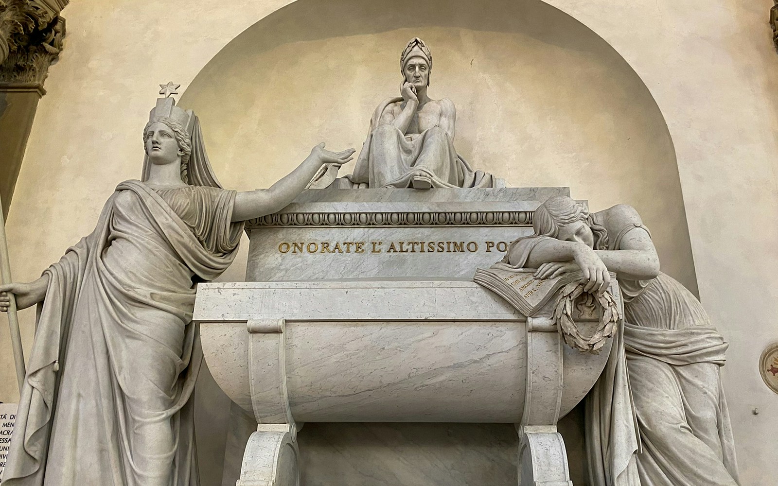 Santa Croce monument in Florence featuring statues and inscriptions.