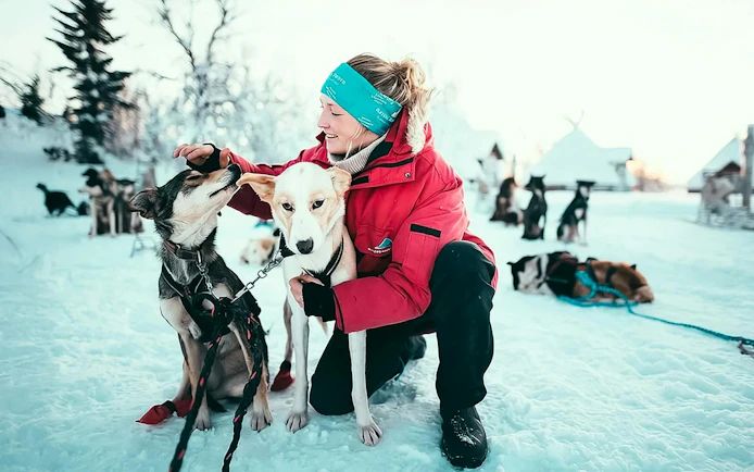 Guests interacting with huskies during self-drive sledding tour in snowy Tromso.