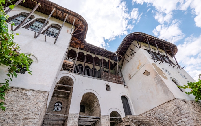 Skenduli House in Gjirokastra, showcasing traditional Ottoman architecture with arched windows and stone walls.