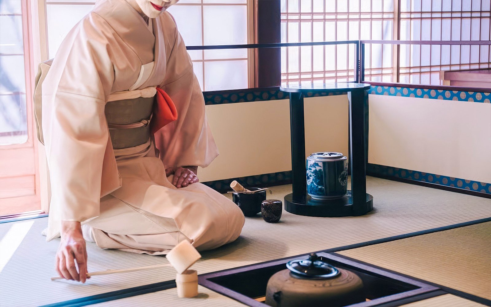 Traditional Japanese tea ceremony with kimono-clad host preparing matcha.