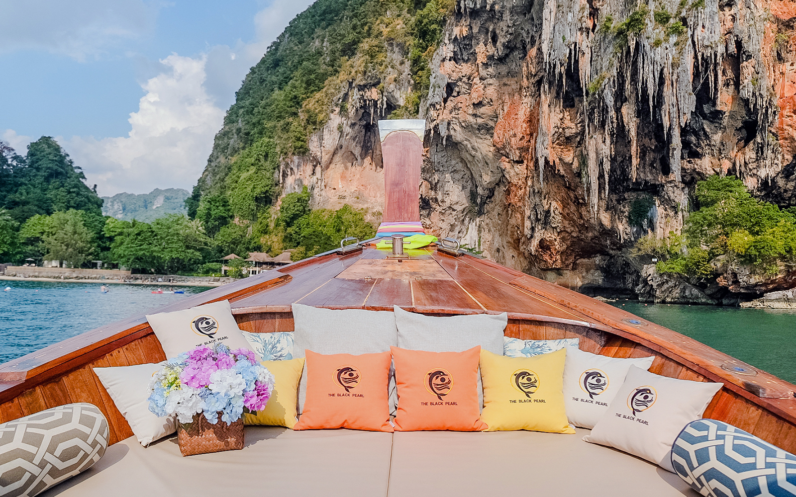 Long tail boat interior with cushions, heading towards Ko Hong cliffs.