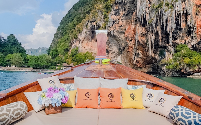 Long tail boat interior with cushions, heading towards Ko Hong cliffs.