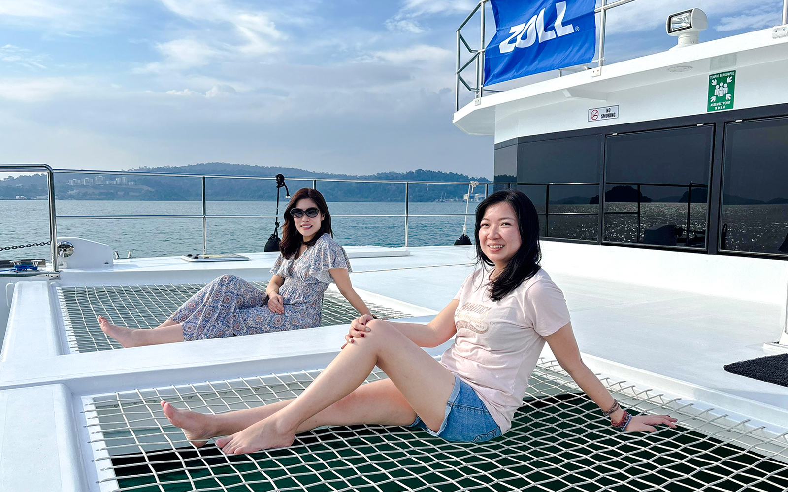 Women relaxing on a jacuzzi net during Langkawi sunset cruise.