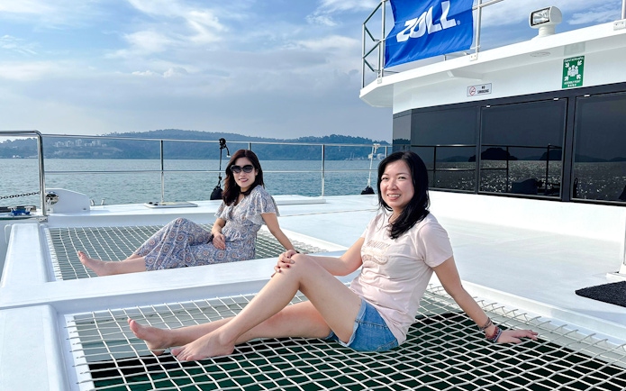 Women relaxing on a jacuzzi net during Langkawi sunset cruise.