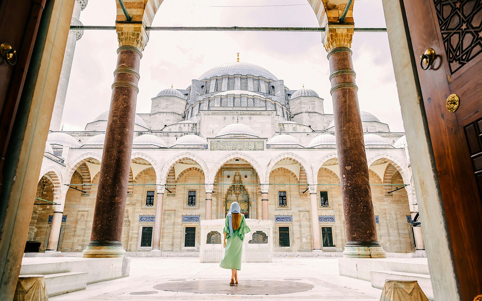 Young girl in headscarf entering Suleymaniye Mosque courtyard, Istanbul.
