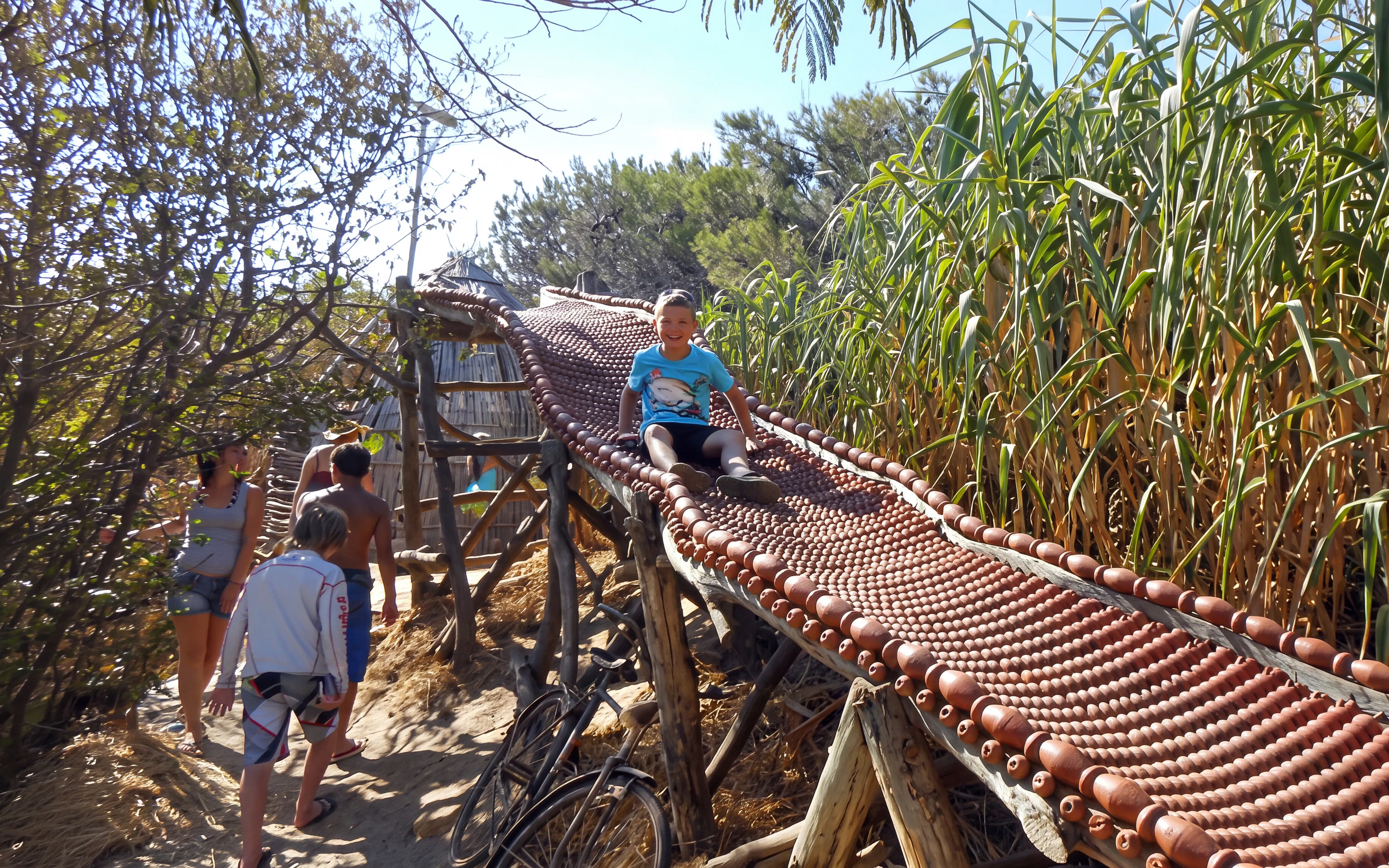 Child sliding on a wooden path at Cape Kamenjak during a private tour from Fažana.