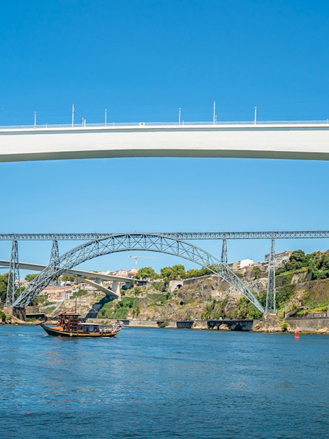 Ponte de São João and boat on Douro River during cruise in Porto, Portugal.