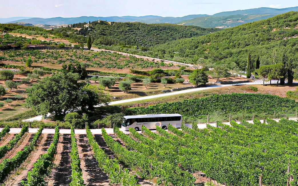 Bus traveling through Chianti vineyards during Florence wine tour.