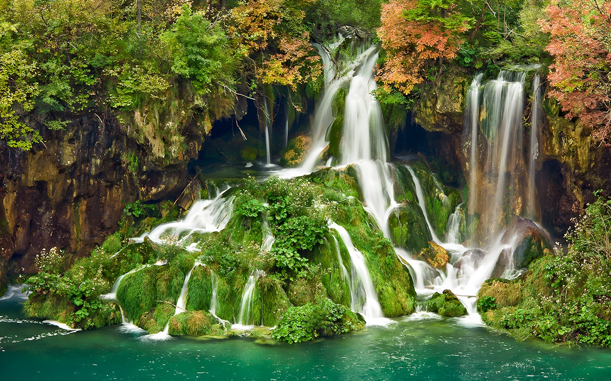 Waterfalls cascading over mossy rocks at Plitvice Lakes National Park, Croatia.