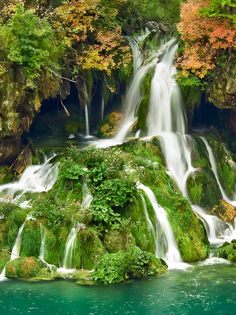 Waterfalls cascading over mossy rocks at Plitvice Lakes National Park, Croatia.