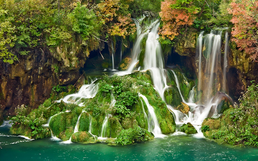 Waterfalls cascading over mossy rocks at Plitvice Lakes National Park, Croatia.