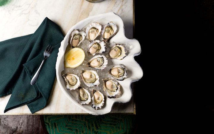 Plate of fresh oysters with lemon at The Emerald Room party.