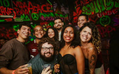 Group enjoying nightlife at Substation Club Rio, Rio de Janeiro, with vibrant graffiti backdrop.