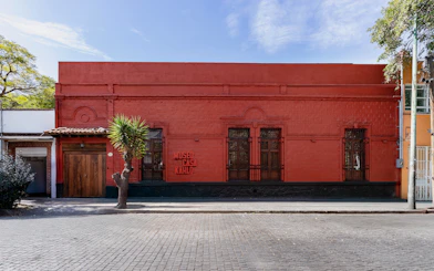Museo Casa Kahlo exterior with red facade and wooden door in Mexico City.