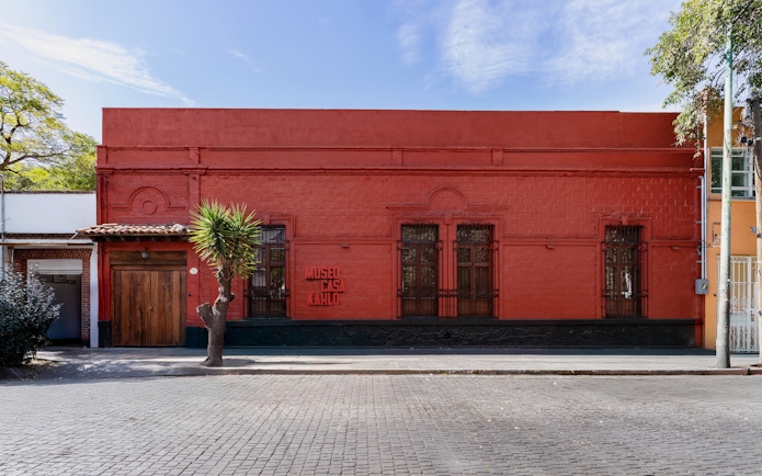 Museo Casa Kahlo exterior with red facade and wooden door in Mexico City.