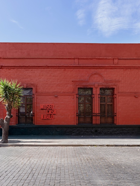 Museo Casa Kahlo exterior with red facade and wooden door in Mexico City.