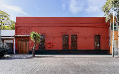 Museo Casa Kahlo exterior with red facade and wooden door in Mexico City.