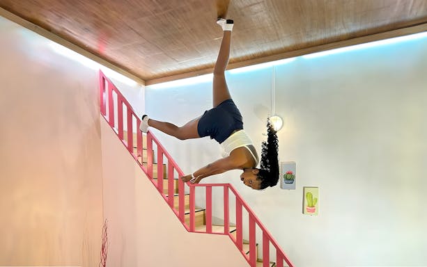 Person posing upside down on stairs at Upside Down World Bali.