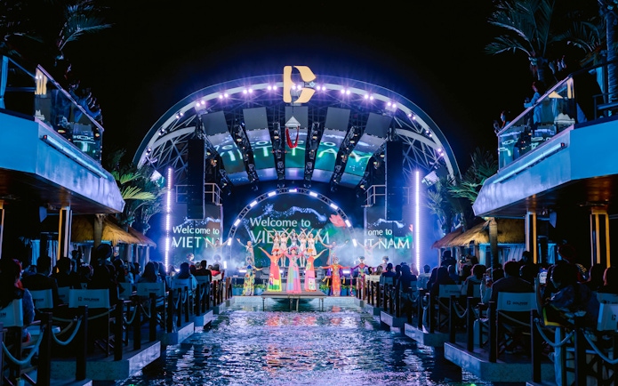 Night show on Dolphin cruise with performers on stage, Vietnam backdrop.