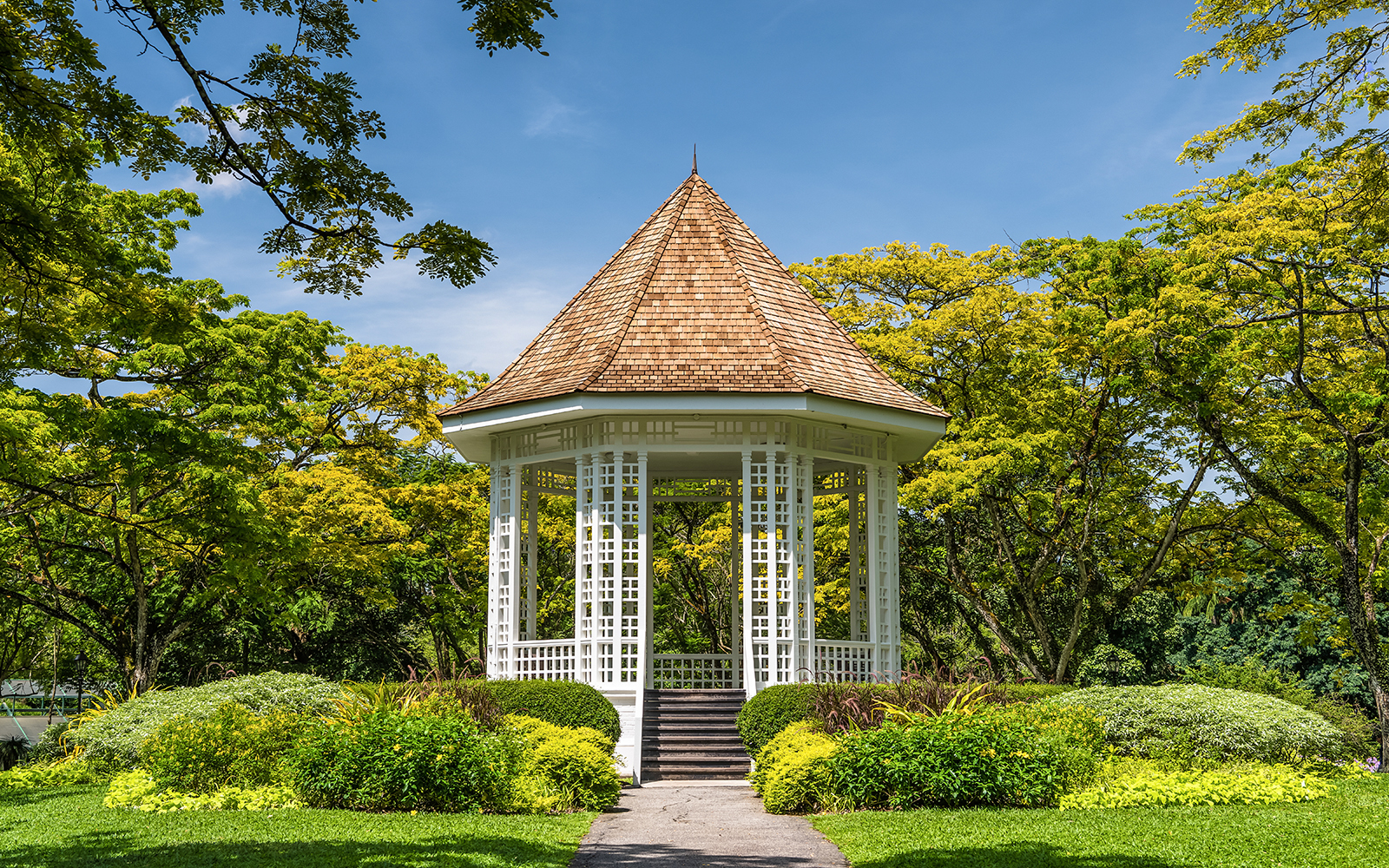 Visitors exploring the lush greenery of the Singapore Botanic Gardens on a sunny day, a popular day trip tour in Singapore