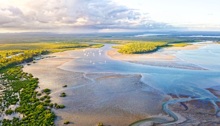 Aerial view of Great Sandy Strait with boats and lush green islands.