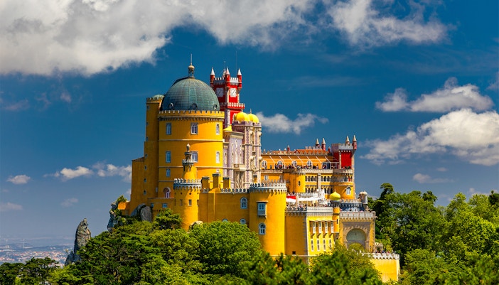Pena Palace in Sintra, Portugal, with colorful towers and lush surrounding park.