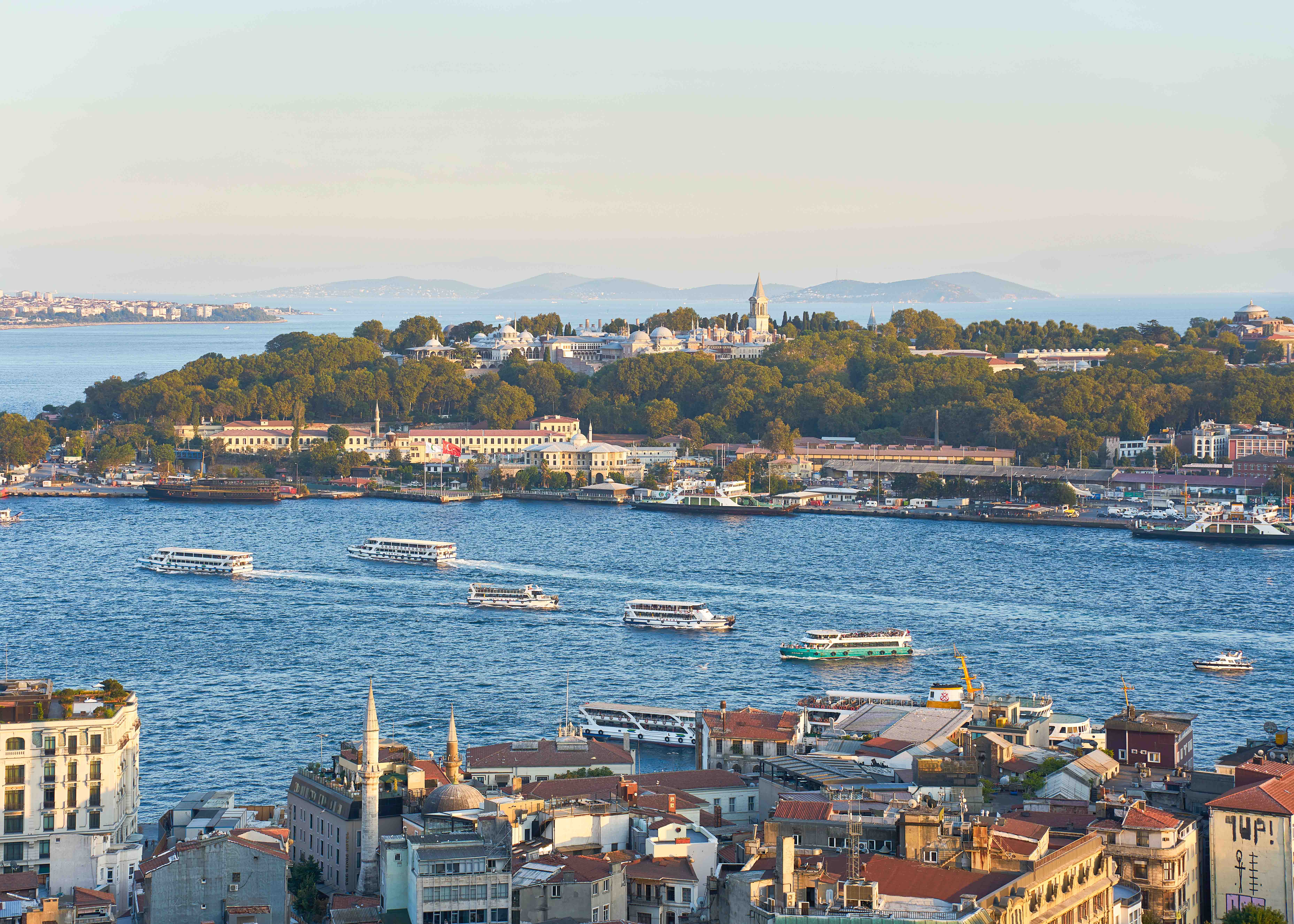 Bosphorus yacht cruising past Istanbul skyline with historic landmarks in view.