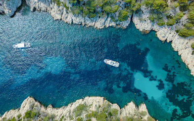Excursion boats navigating the turquoise waters of Calanques de Cassis, France.