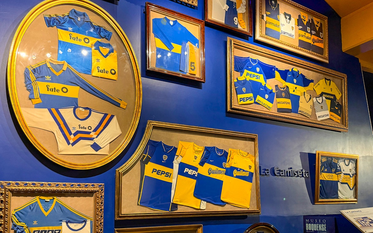 Framed Boca Juniors jerseys displayed inside La Bombonera stadium museum.
