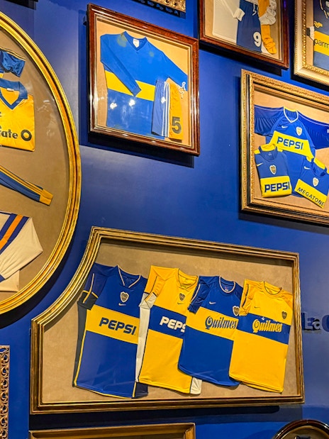 Framed Boca Juniors jerseys displayed inside La Bombonera stadium museum.