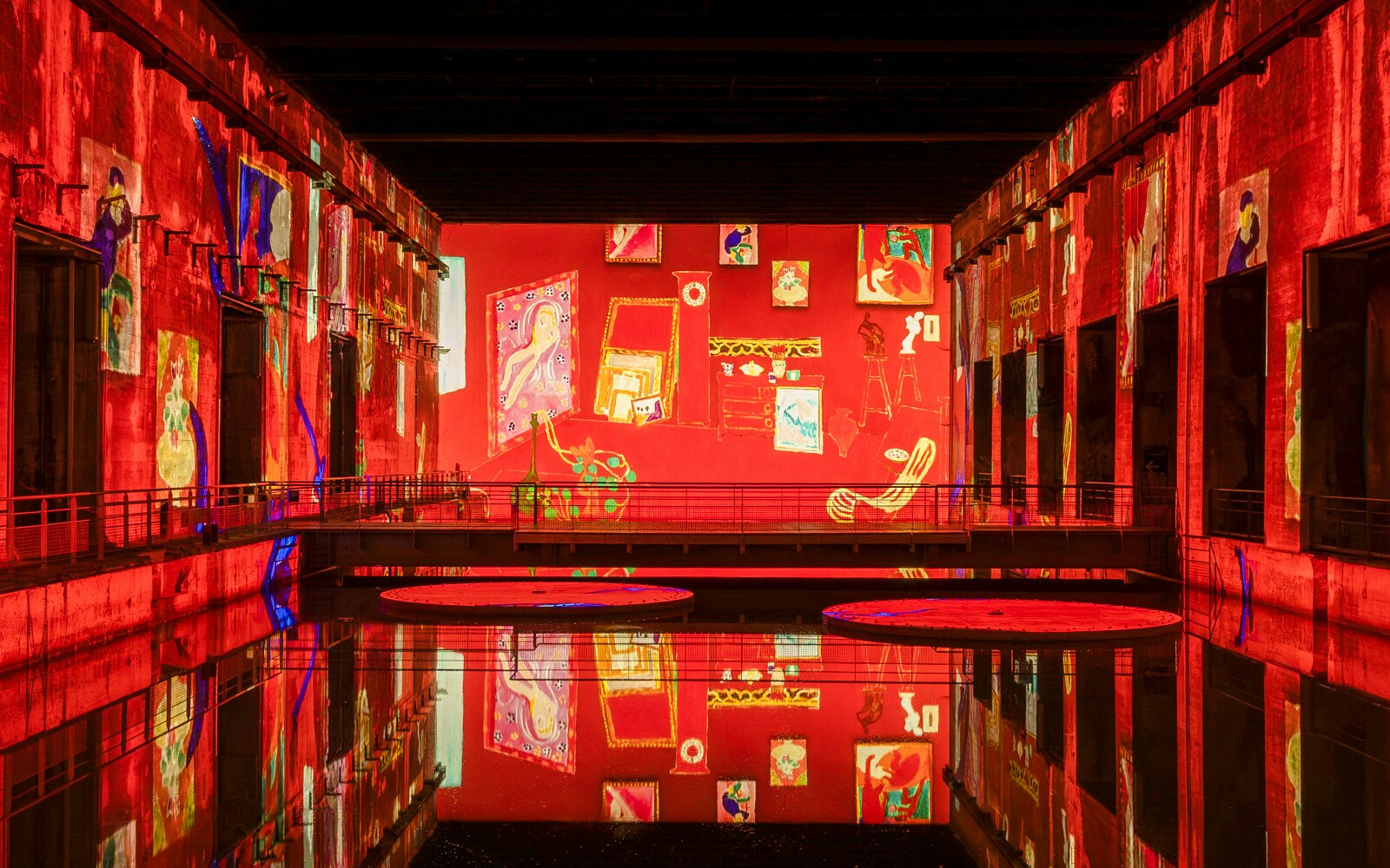 Matisse artwork projections at Bassins Des Lumieres exhibition, vibrant red reflections.