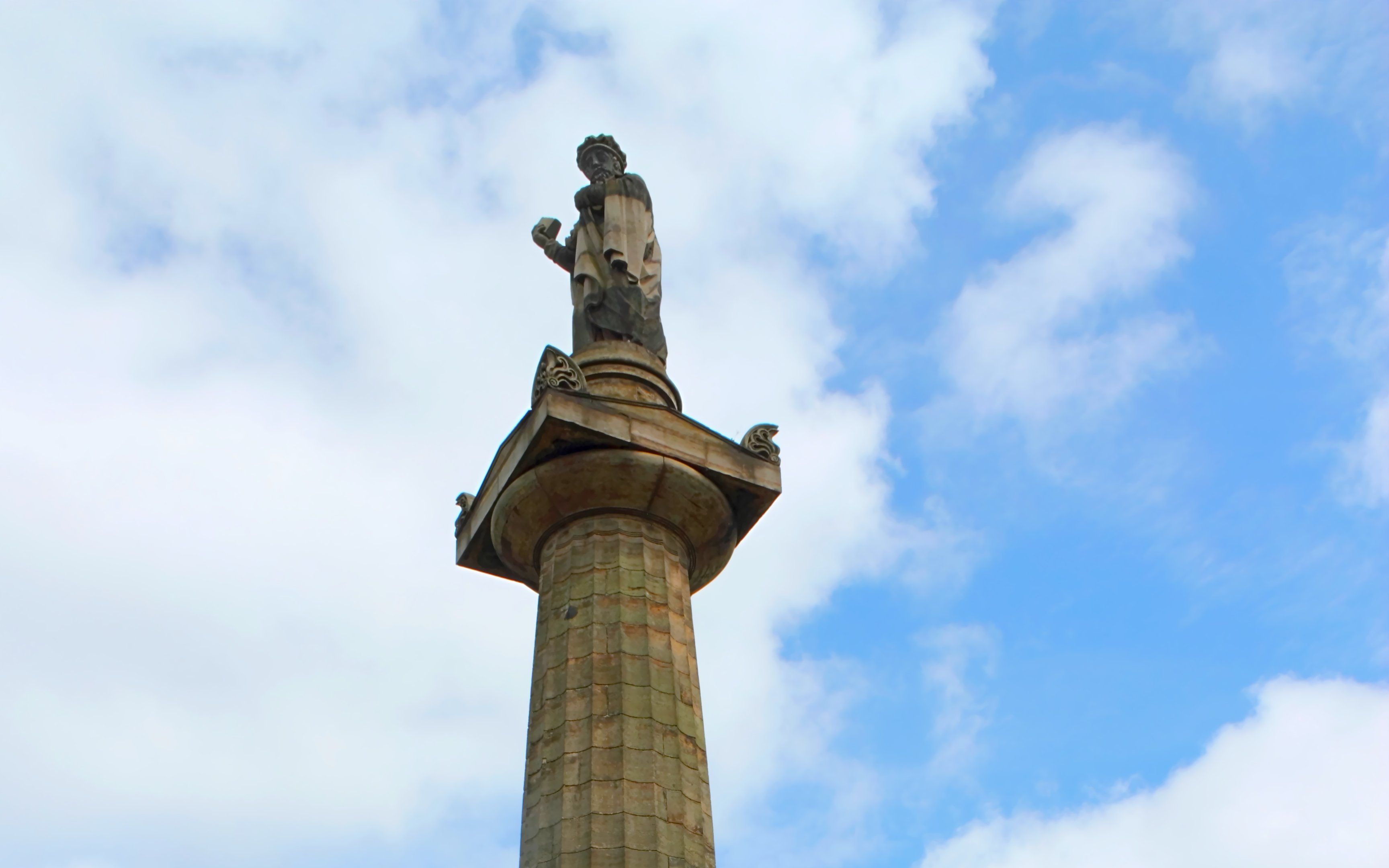 John Knox Monument in Glasgow against a blue sky.
